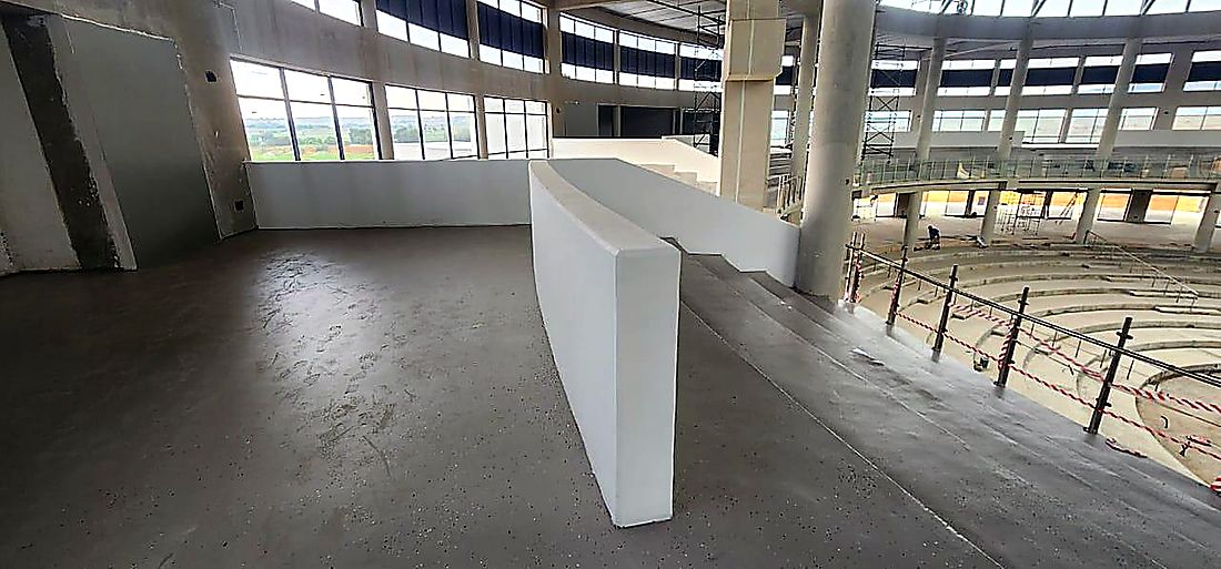 Double volume commercial interior with curved reception bulkhead nearing completion