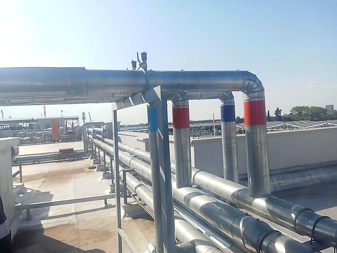 Insulated chilled water flow and return pipework routed across a commercial rooftop
