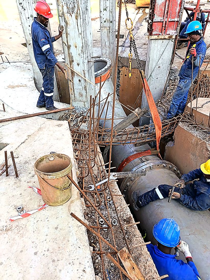 Malanc Projects crew rigging a steel pipe section into a concrete chamber